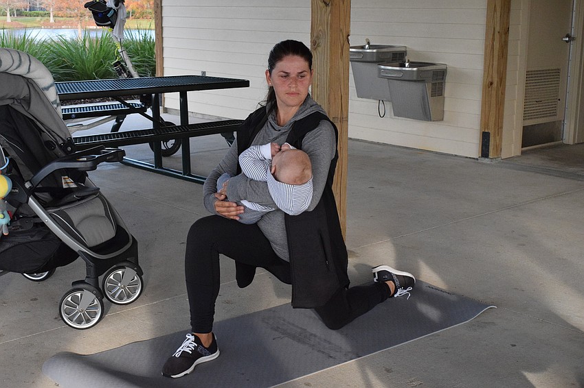 Arbor Grande's Victoria Korotkova lunges with her 3-month-old son, Ian Korotkov, in her arms.