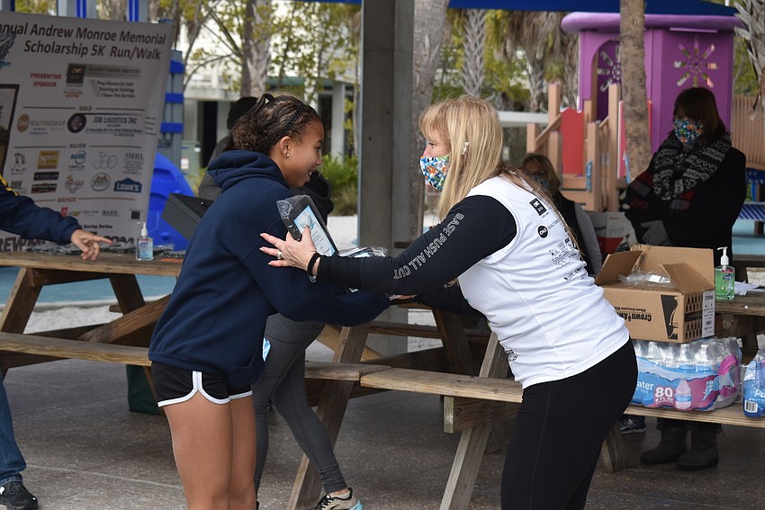 Jasmine France receives her winner's plaque from Stacey Monroe.
