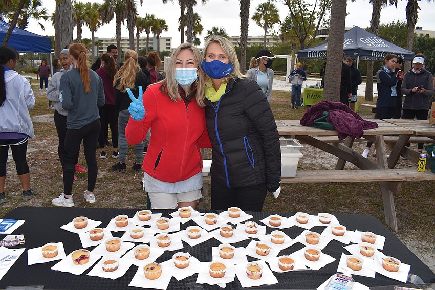Ashleigh Howle and Kelly Fox hand out muffins after the race.
