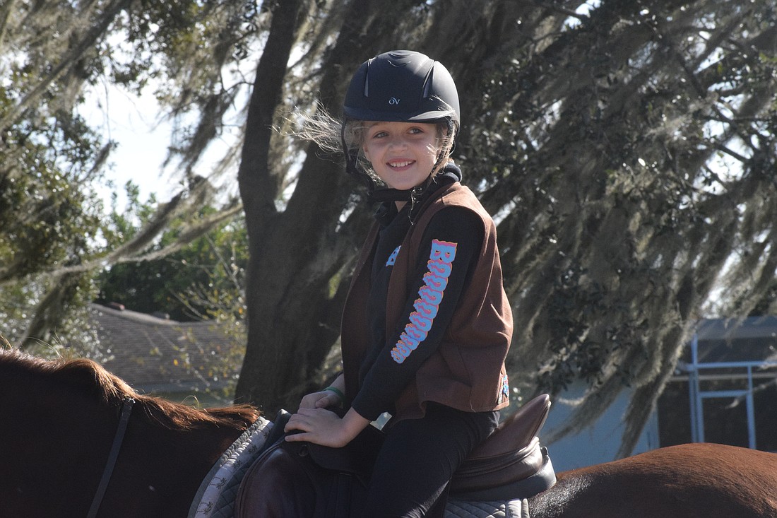 Phoebe Jessop, a member of Girl Scout Troop 97, looks over at her fellow scouts during while riding. Horseback riding was one of the outdoor activities the troop could do safely. Photo by Liz Ramos.