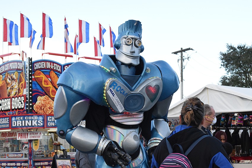Rock-It the Robot talks to fair-goers about cats while walking along the midway.