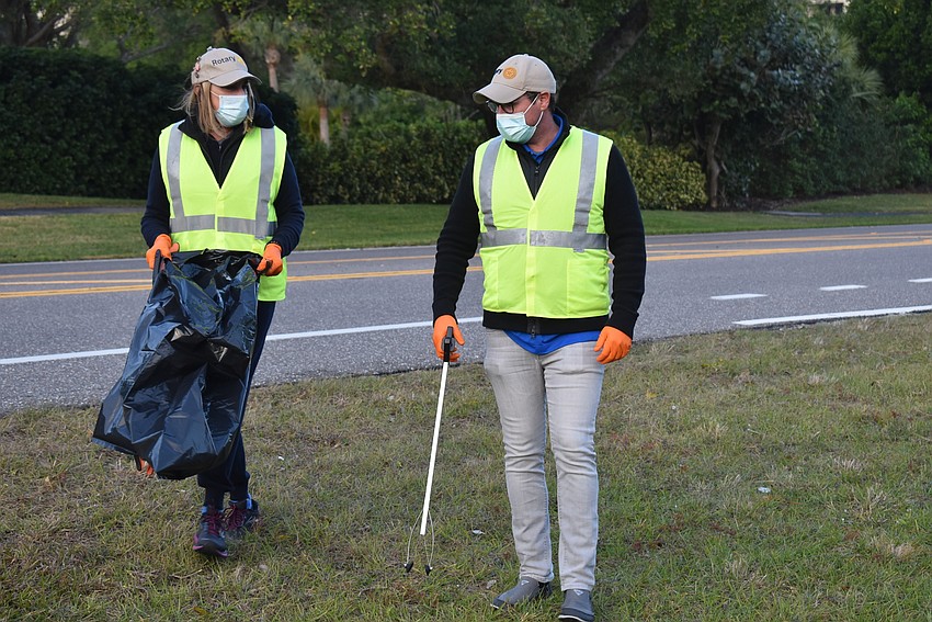 Nancy Rozance held the bag while Bo Fuller grabbed the trash.