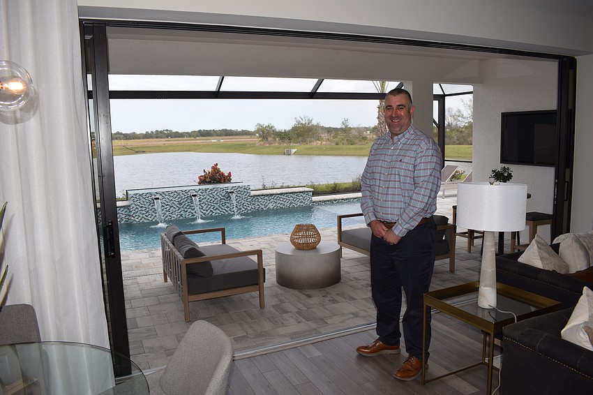 Pulte Homes sales associate Andrew Basco shows how the inside living area flows into the lanai in a Sapphire Point home.
