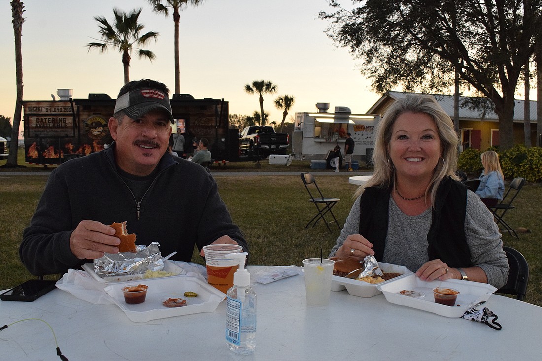 Greenbrook&#39;s Matt and Lisa Buck chow down on food from Cigar City Smokers during their first Ranch Nite Wednesdays. The food trucks at the event provide multiple options for people to indulge.