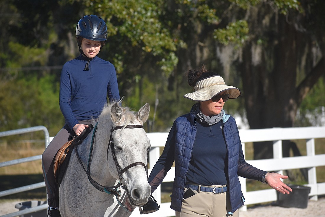 11-year-old Charlie Rayner practices riding with the help of his mom, Erin Rayner, the owner of Opportunity Farm. Charlie Rayner is riding 18-year-old Popcorn.