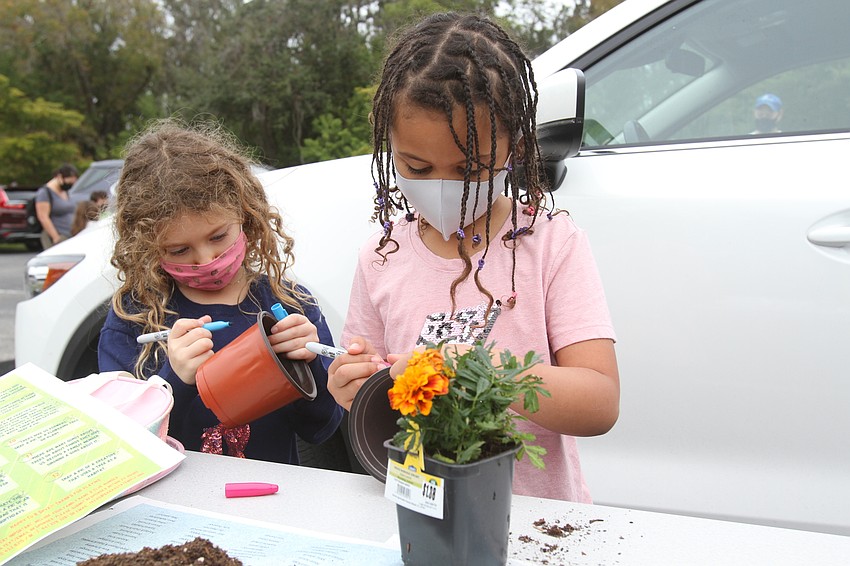 Alana Derowe and Eliana Lasko drew on their flower pots.