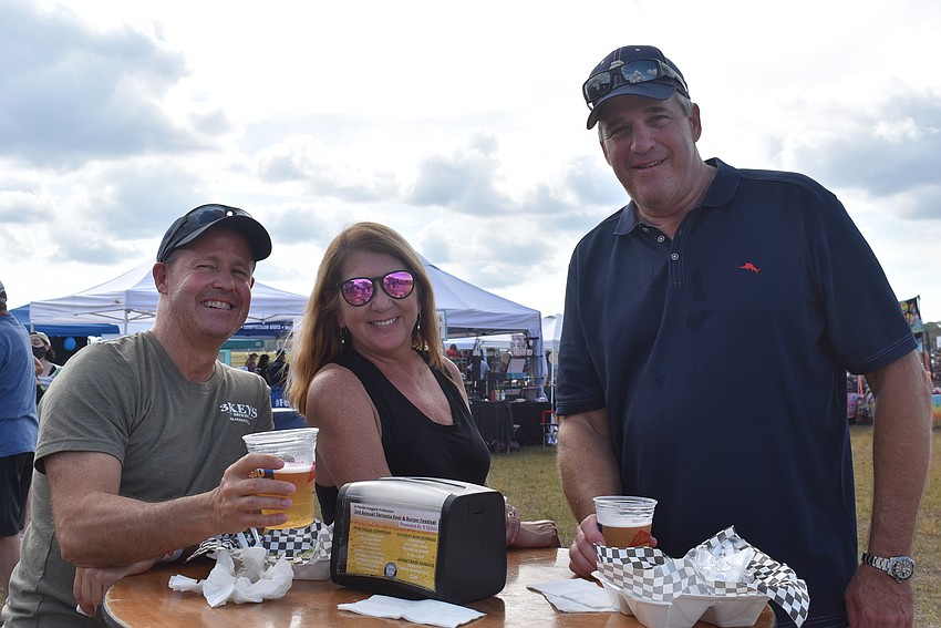 Lakewood National residents Jeff McGuire, April McGuire and J.D. Hedin tried a cheeseburger and pulled pork reuben from Smokin Momma Lora's. The former New England residents were excited to watch Tom Brady play that afternoon.