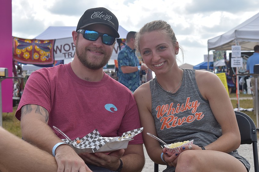 Kyle Strater and Jay Strater are visiting Sarasota from the Philadelphia area. Kyle tried a cheeseburger from Smokin Momma Lora's BBQ, while Jay ate potato salad from the same vendor.