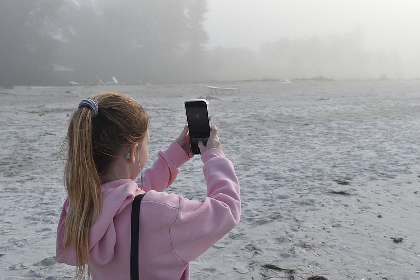 Giana Clark tries for a photo of the sun through the clouds.