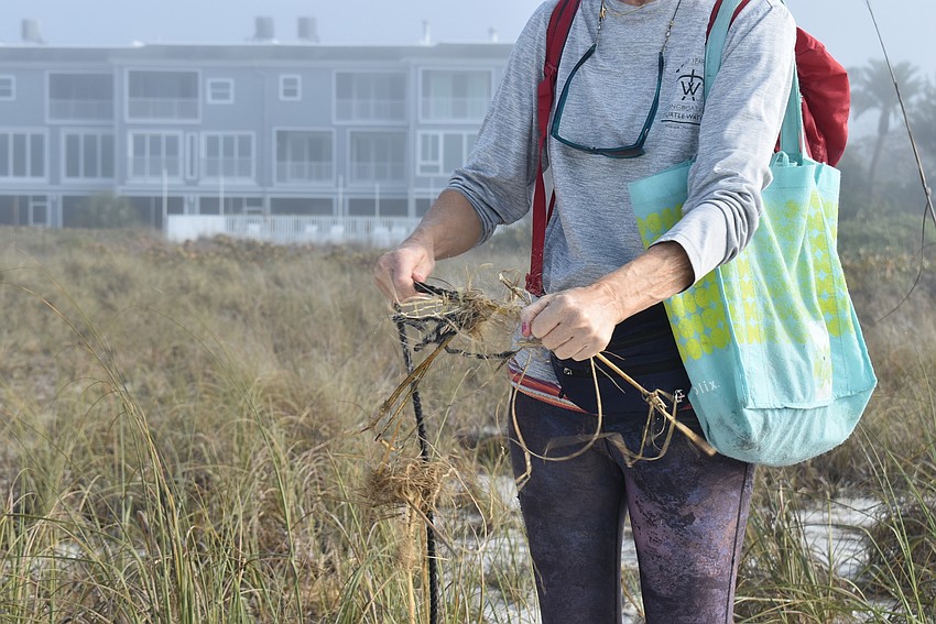 Cyndi Seamon removes the organic material wrapped around a rope.