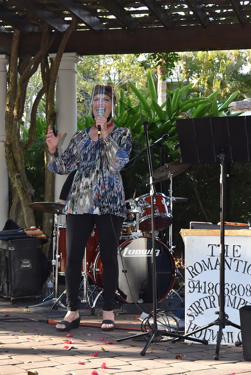 Cynthony Palmer sings from behind a face shield.