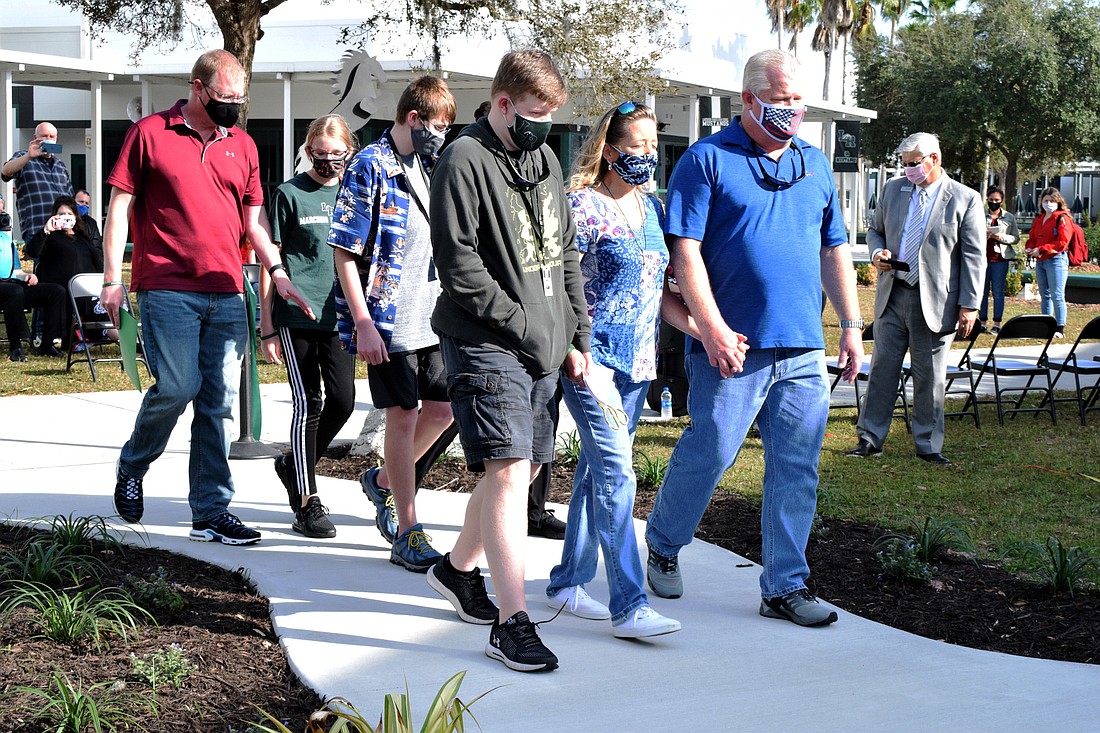 Dan Powers, along with Katie Powers, Robert Powers, Rebecca Powers, Cory Coyner, Shayleen Coyner and Scott Coyner, are the first to walk along the Mustang Memorial Walk.