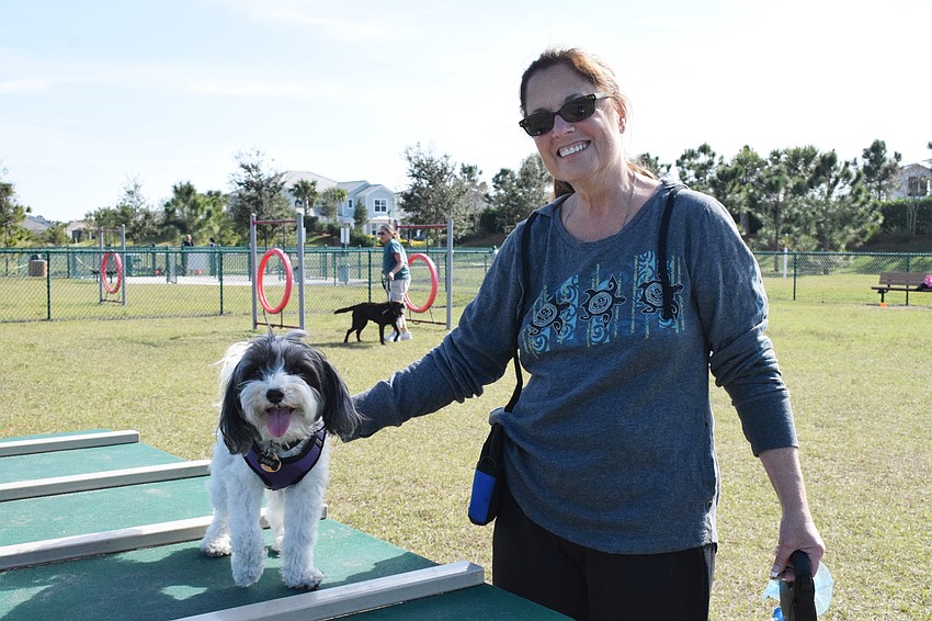 Esplanade's Cheryl Dobbs guides her dog, Pepe, across the dog walk. 