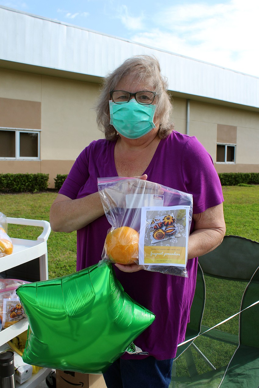 Beth Bourbeau hands out an orange pomander craft families can use to make their home look and smell good.