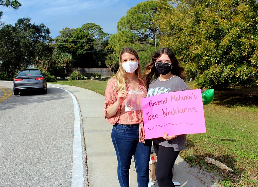 Melanie Epstein and Sitar Ben-Herut give out tree of life necklaces.