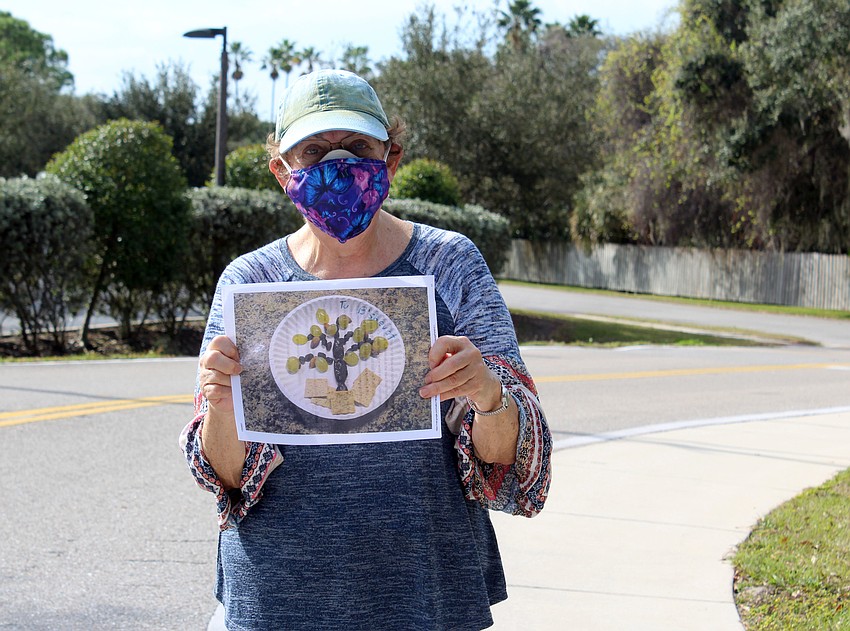 Anne Schimberg hands out fruit so families can make edible trees.