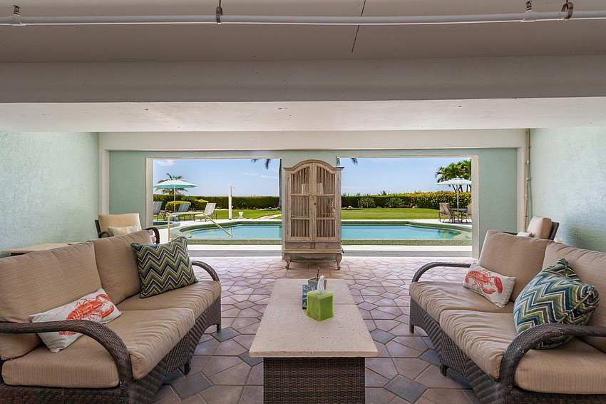 A beachfront pool features a shaded lounge area.