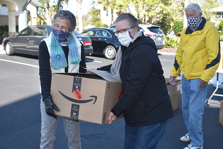 Sue Wertman and Ann Quackenbush team up to carry a box to the car.
