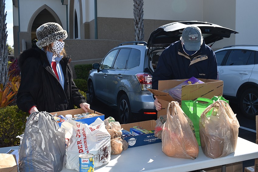 Karen and Marc Fors create a bucket brigade to get donations packed away.