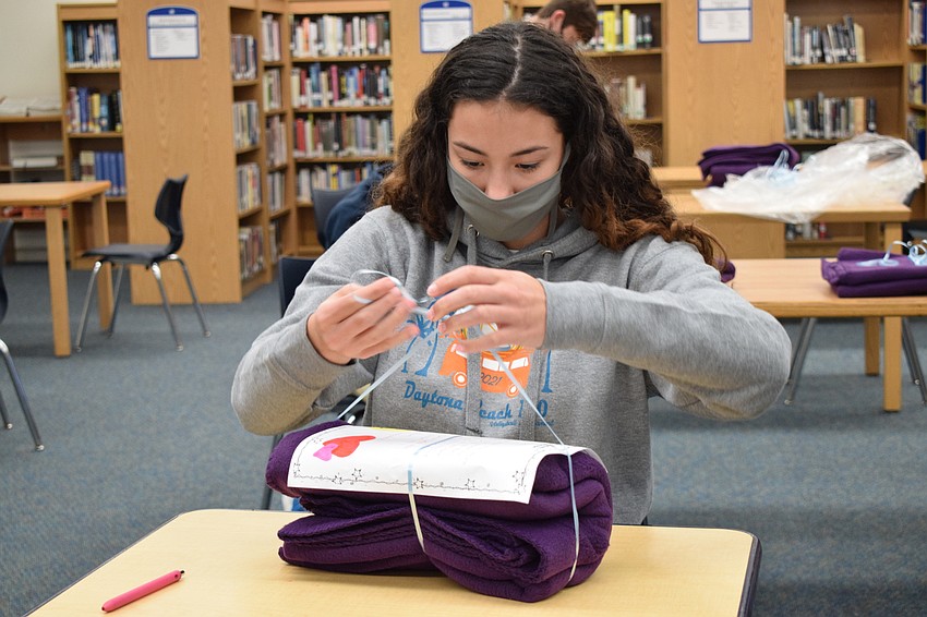 Freshman Annabelle Basler ties her note to a blanket. She wrote a letter reminding the recipient that other people care.