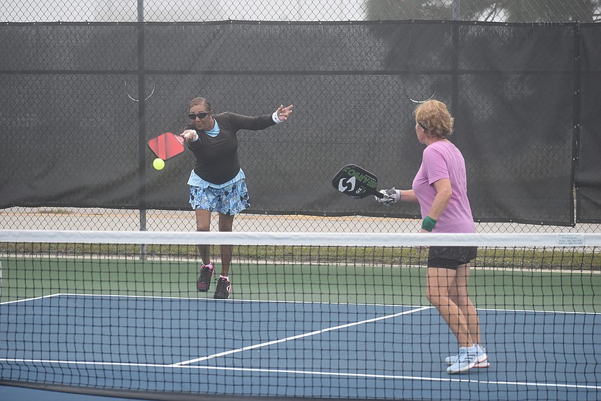 Stonybrook resident Jacque Marks returns a serve while River Strand resident Roxann Viera watches on. Marks and Viera won their first match 15-14.
