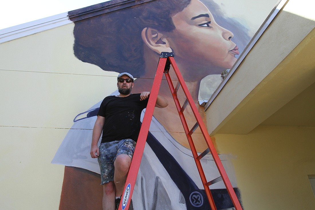 Truman Adams has painted a large mural of a child blowing bubbles at Forty Carrots Family Center.