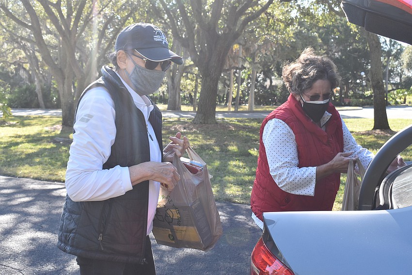 Karen Gary and Judy Tobias unload a donor's car.