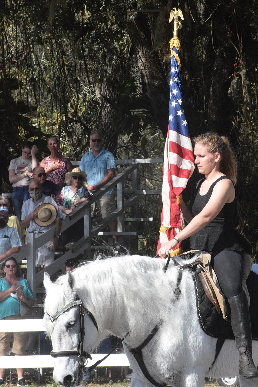 Samantha Dittman brings out the American flag for the National Anthem as the beginning of the training session.