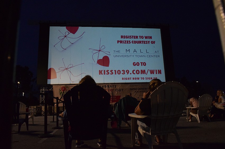 People relax in Adirondack chairs while waiting for 