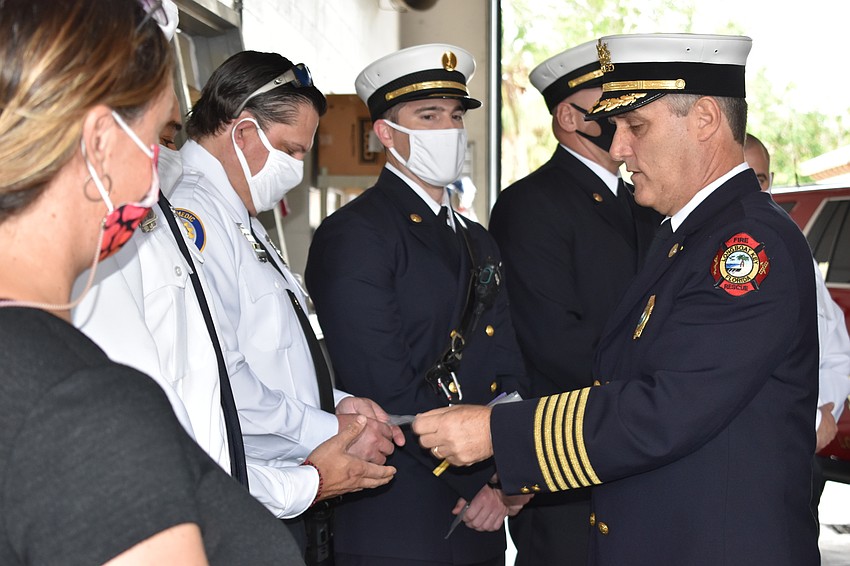 Fire Chief Paul Dezzi (right) distributes awards during Tuesday morning's ceremony.