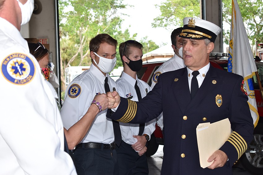 Fire Chief Paul Dezzi (right) offers congratulations during Tuesday morning's ceremony.