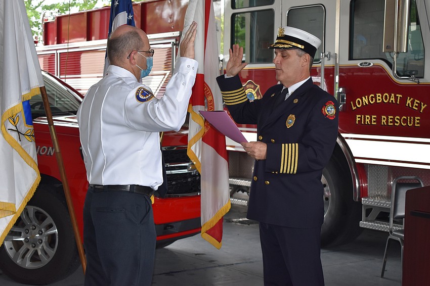 Newly-appointed Assistant Chief John Curran gets sworn in by Fire Chief Paul Dezzi at Tuesday morning's ceremony.