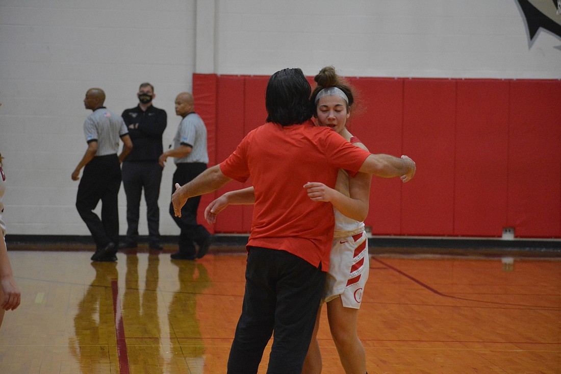 Mooney Coach Rico Antonio and sophomore guard Olivia Davis hug after the win.