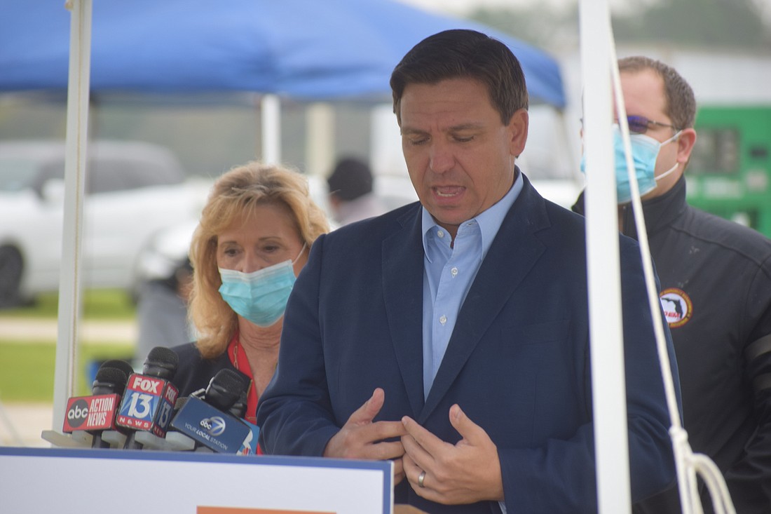 Manatee County Commissioner Vanessa Baugh stands behind Gov. Ron DeSantis as he addresses the media Wednesday morning at Premier Sports Campus in Lakewood Ranch.