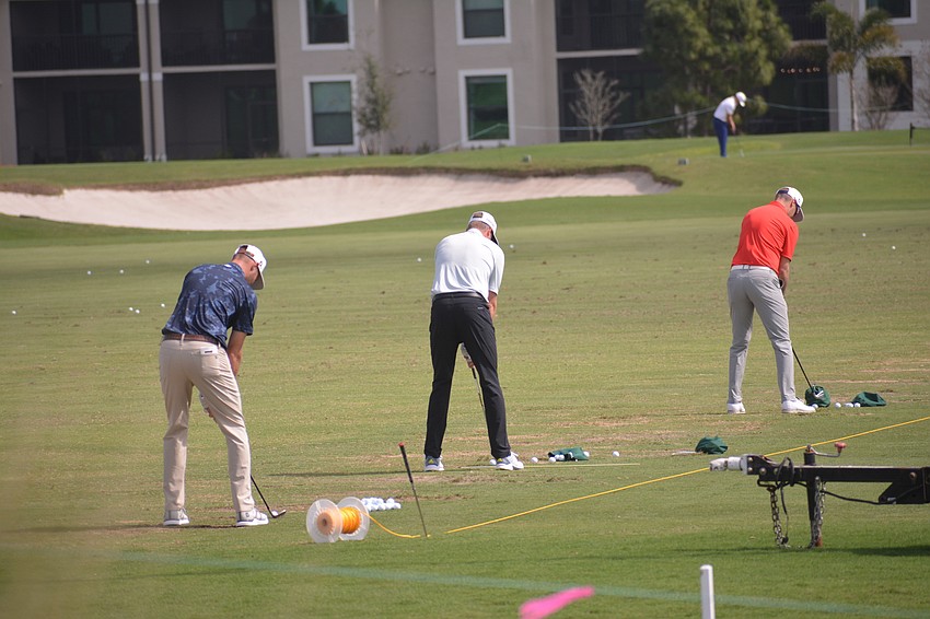Golfers use the driving range at Lakewood National to get ready for their round.
