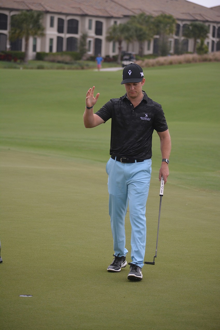 Grant Hirschman waves to the crowd after a par on the No. 18 hole at Lakewood National. Hirschman would finish at one over par for the day and for the tournament.