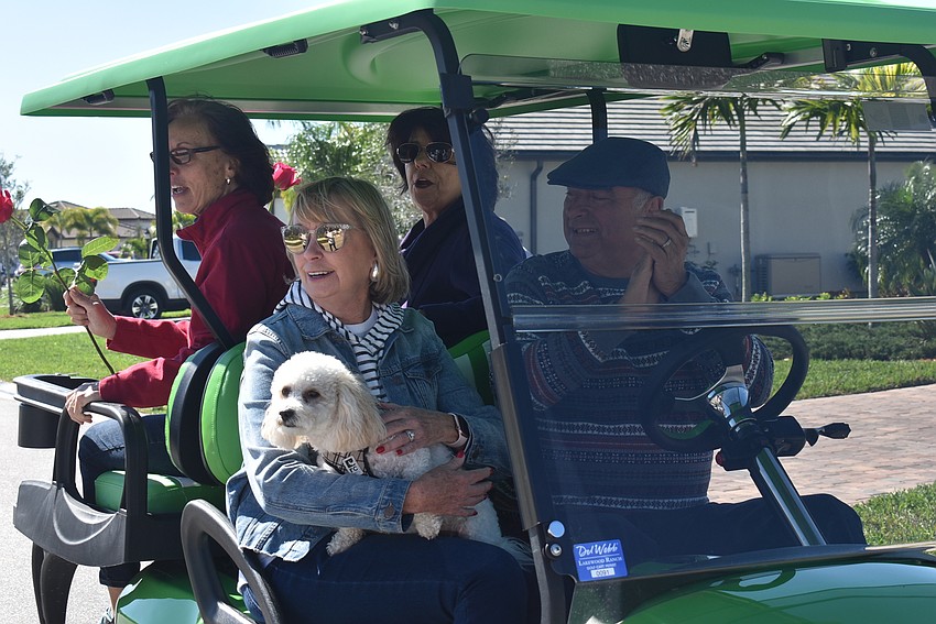 Dolores Trujillo, Linda Chambers, Carol English and Herman Martinez ride in a  golf cart with Coco. Martinez helped organize the parade.