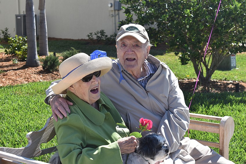 Rose and Reinhard Bauer are surprised by the appearance of their grandson, Scott Bauer, and his wife, Jen Bauer, who made a surprise visit to Rose's 100th birthday parade at Del Webb.