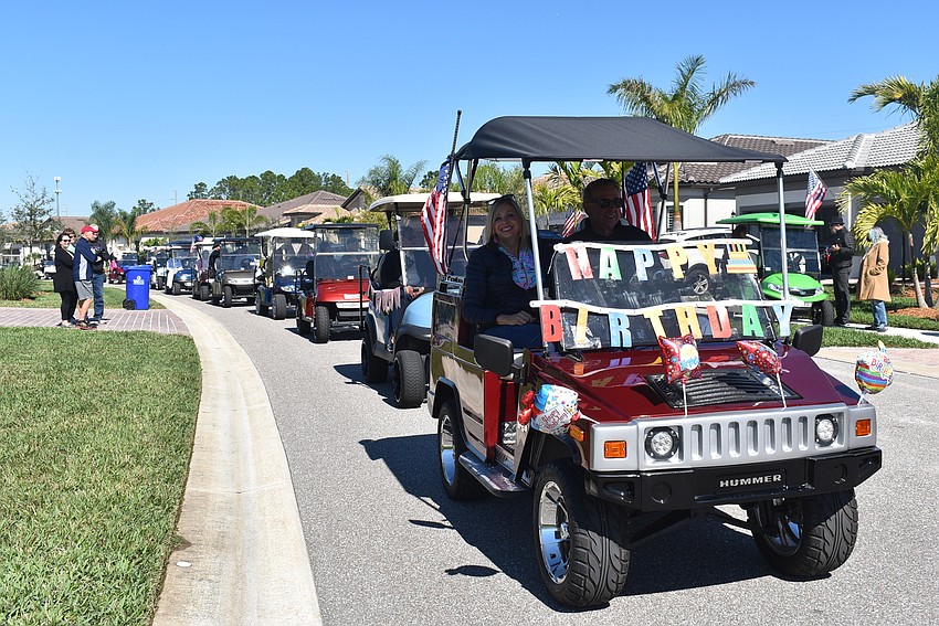 Del Webb residents Peggy and Jerry Hufford are part of a long procession of vehicles passing by Rose Bauer.