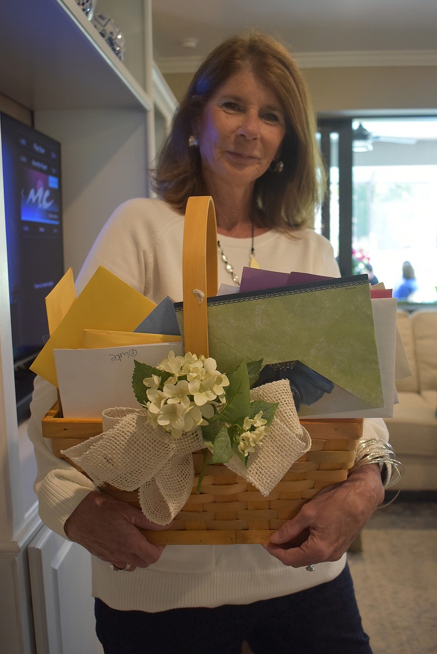 Susan Bauer holds nearly 200 birthday cards written to Rose Bauer, her mother-in-law for Rose Bauer's 100th birthday.