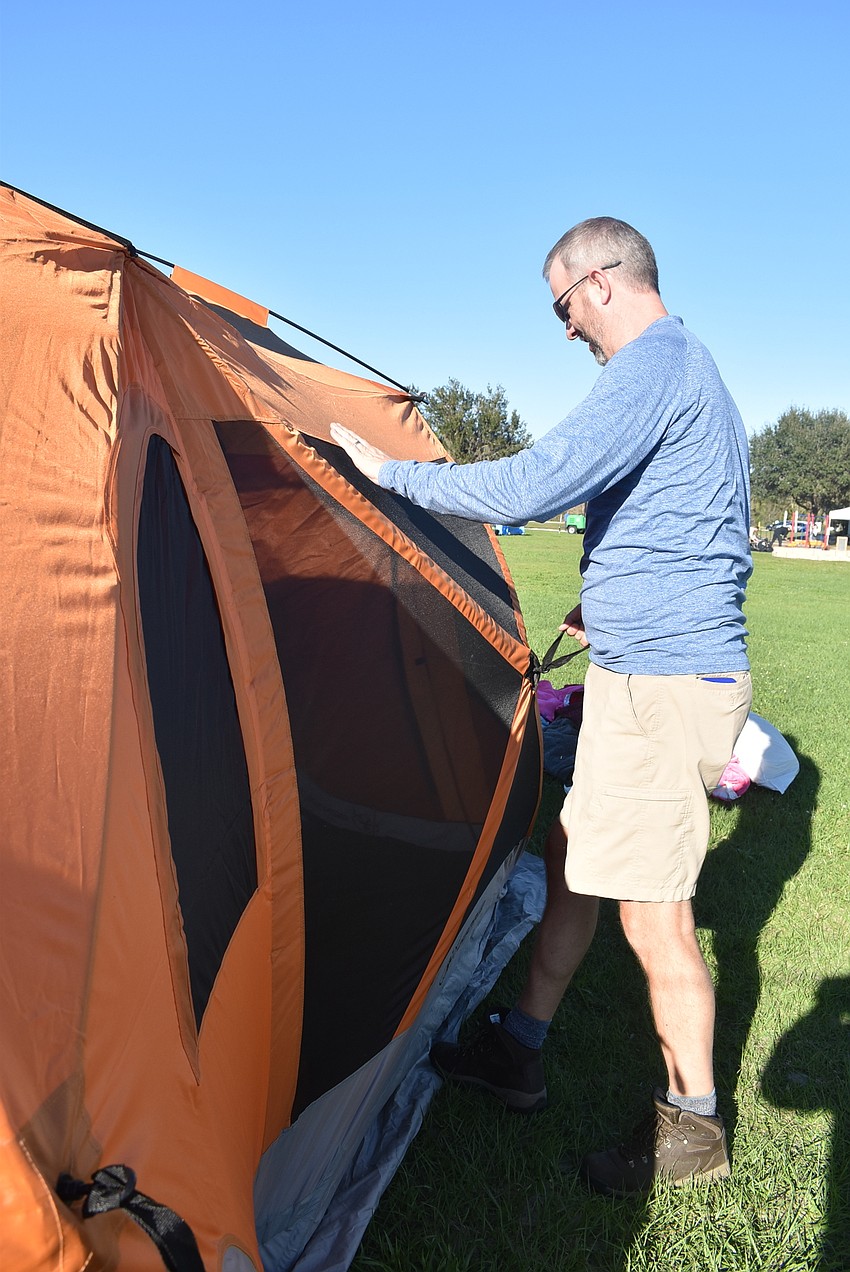 Greenbrook resident Bill Poulton sets up his family's tent. Poulton went home afterward to enjoy a night to himself while his wife, Tara Poulton, stayed with their kids and her best friend at the campout.