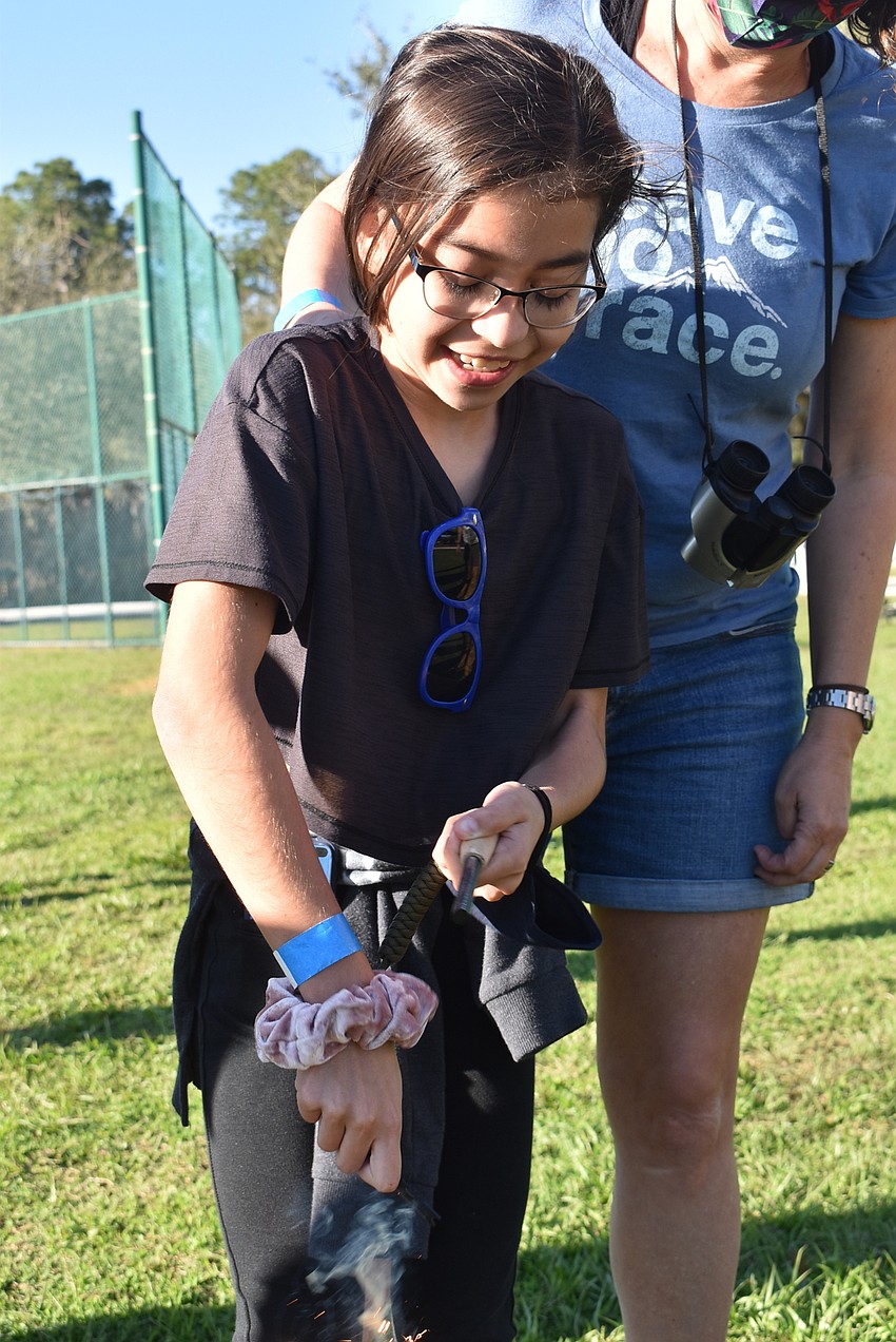 Parrish resident Juliana Martinez, 10, lights a spark using a rod made of ferrocerium, a synthetic alloy made from iron and cerium.