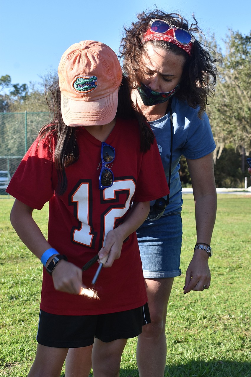 Lakewood Ranch resident Adriana Nazario, 10, lights a spark using a rod made of ferrocerium, a synthetic alloy made from iron and cerium.
