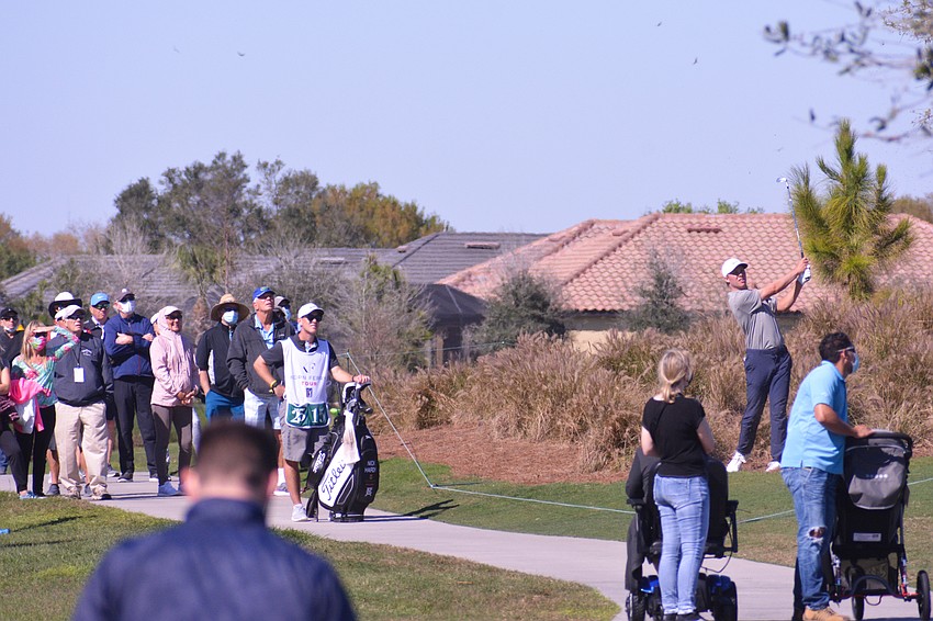 Nick Hardy (right) hits from nearly outside the ropes on No. 18 as a crowd watches his shot. Hardy would bogey the hole and finish one over par.