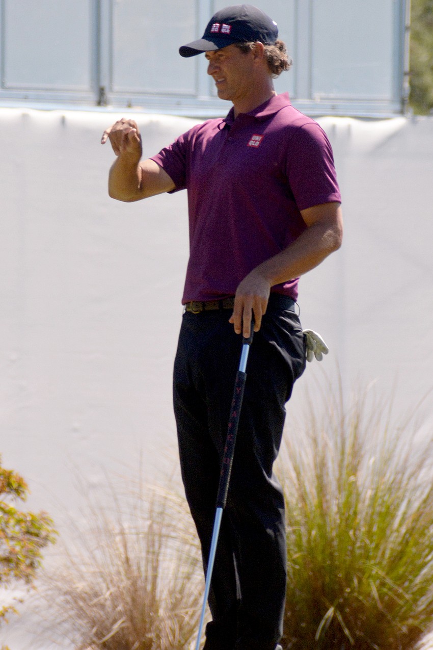 Adam Scott visualizes a putt on the No. 10 green with his hands. Scott would par the hole and finished his round even par.