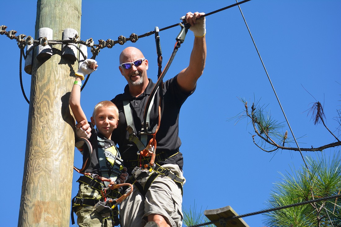 Tucker Ritchey, and his dad, Winston Ritchey, enjoy the obstacle courses at TreeUmph! File photo.