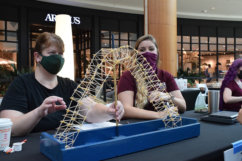 Volunteers Molly Williams and Allie Bittle measure and weigh a bridge.