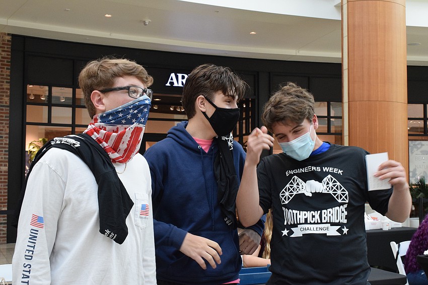 Suncoast Polytechnical High School freshmen Austin Bilello, Anton Becker and Vince Schweig watch as Schweig's bridge cracks under six pounds of pressure.
