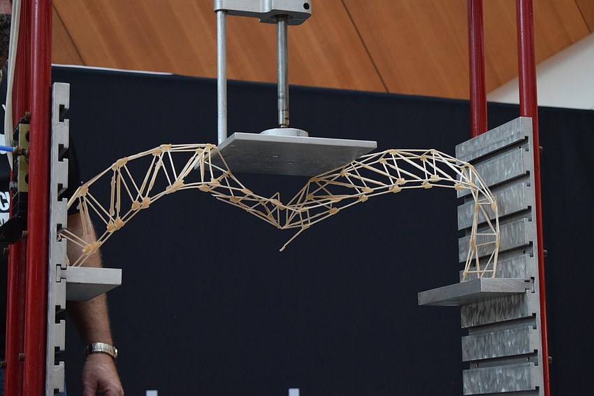 An arch bridge breaks inward under pressure.