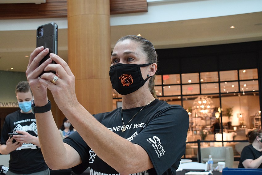 Staci LaPorte, a math teacher at Suncoast Polytechnical High School, takes video of her bridge being tested.